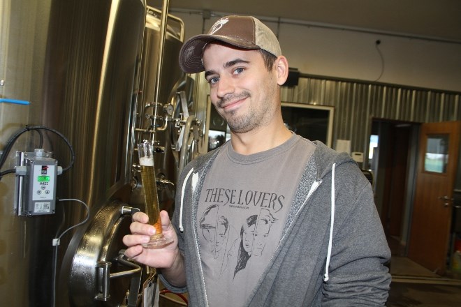 George Renner, co-owner of Dawson Trail Craft Brewery, checks a sample of a batch in the brewing room. (Karen McKinley photo)