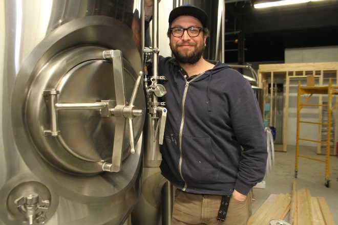 Graham Orser, president and brewmaster of Forty Six North brewing Company, the latest brewery to open in Sudbury, stands with one of the tanks in the soon-to-be brewing and bottling room. (Karen McKinley photo)