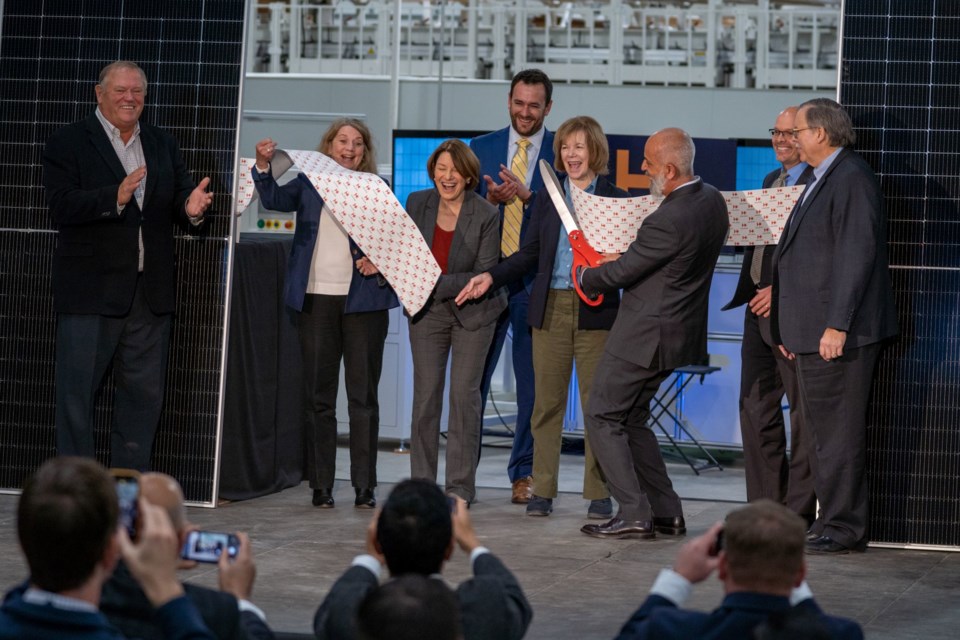 Heliene CEO Martin Pochtaruk (with scissors) cuts the ribbon on 
a new 450-megawatt solar module manufacturing line in Mountain Iron, Minn. with Senators Amy Klobuchar and Tina Smith on hand (Heliene photo)