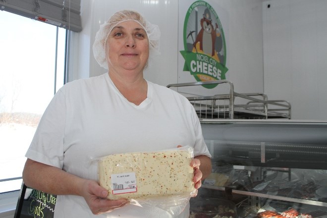 Nicole Paquin show off one of the many cheddar bricks available for sale at Nickel City Cheese at the factory store in Azilda. 