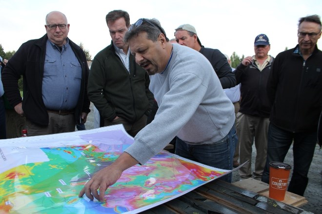 Richard Zamoroz, senior project geologist with New Age Metals, points out locations of core samples while guests examine pieces at the core shack in River Valley before heading to the site. (Karen McKinley photo)