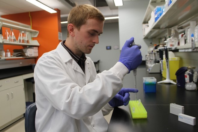 Kyle Mispel-Beyer, research associate, shows how samples will be processed once they arrive at the lab at the Health Sciences Research Institute in Sudbury. 