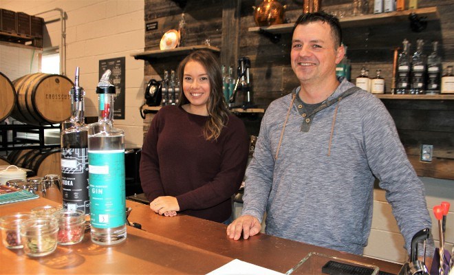 Shane Prodan, owner and proprietor of Crosscut Distillery, and Sarah Del Monte, marketing and events coordinator, show off the triple grain vodka and local harvest gin that are the flagship products, along with some common ingredients and botanicals used in the distilling process.