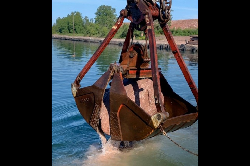 Trade West Inc. of Nevada removes the last rock in the now-deepened west channel at the Soo (Michigan) Locks (U.S. Army Corps of Engineers photo)