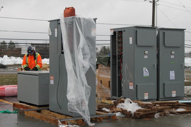 A crew from Steel Control Services worked to install a Tesla SuperCharger in late November. The infrastructure is a Northern Ontario first for the California-based car maker, which is planning to roll out 15 charging stations across the North. (Lindsay Kelly photo)