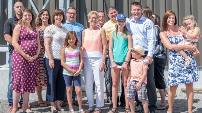Ontario Premier Kathleen Wynne (centre) visited Espanola last August to speak with Greenhouses Canada president Jeff Scharf (right, in blue shirt) about his building technology.