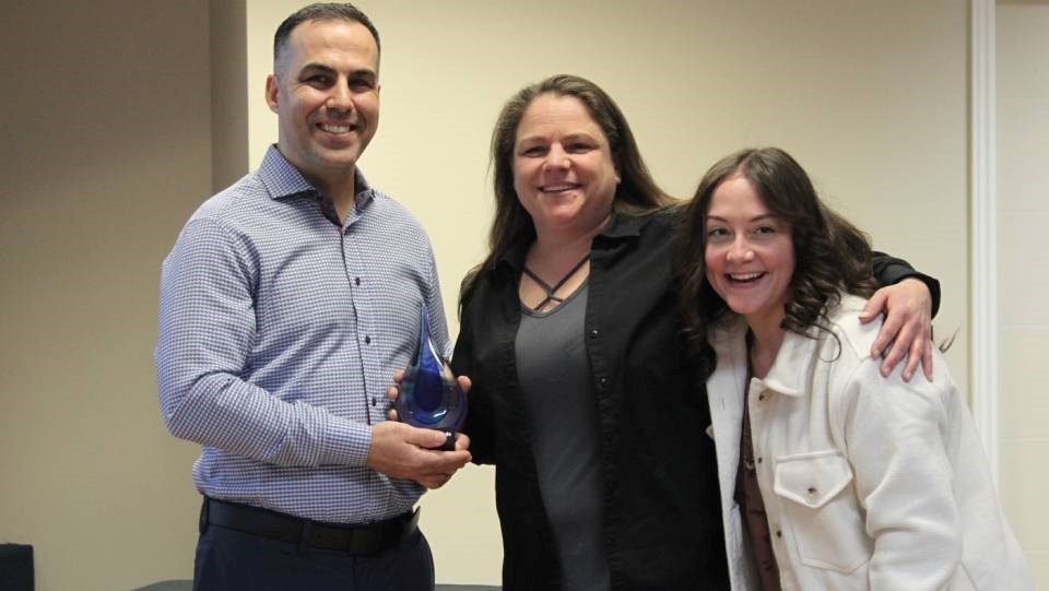 Ryan Forigo presents a Stellar Award to Nicki Lavoie (centre), while her mentee Jenna Shambrook looks on.