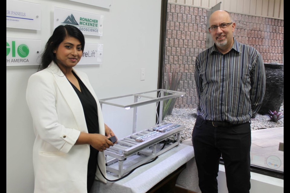 Debapriya Chatterjee, coordinator and marketing specialist at Northern Prosperity, and company president Eric Maag are seen with a model of the CoreLift, an adjustable core-logging table that reduces strain and increases productivity for geologists logging drill core.