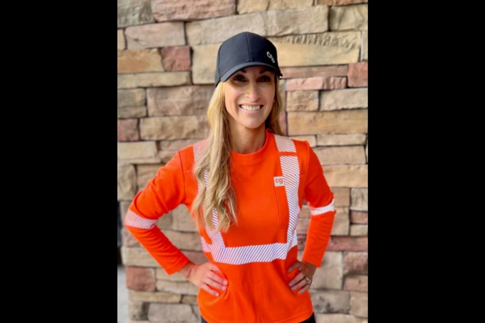 Coveragalls CEO Alicia Woods models the company's new high-visibility T-shirt that's made from recycled plastic bottles.