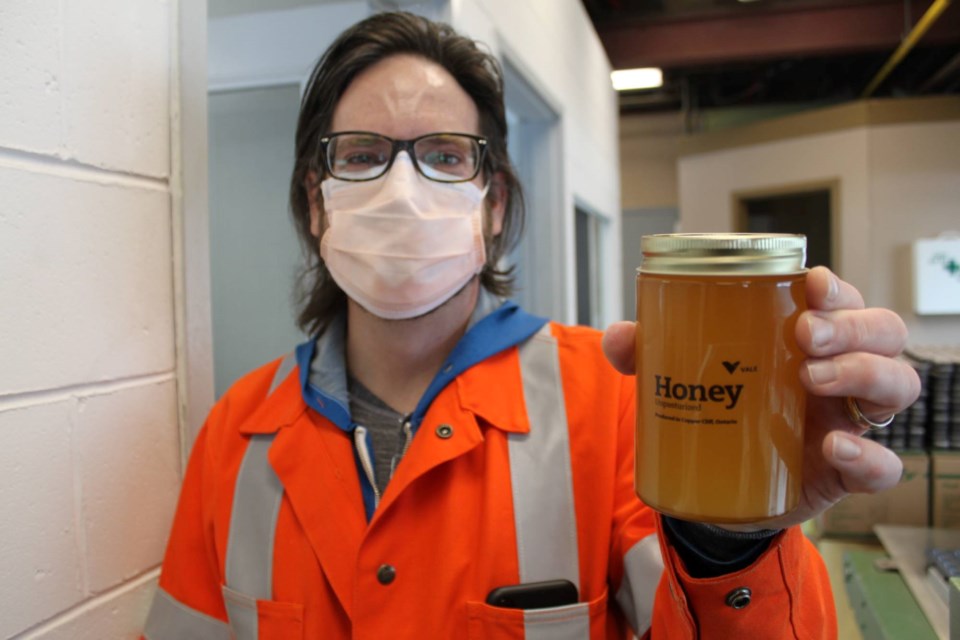 Quentin Smith, a project engineer in the environmental department of Vale’s Sudbury operations, holds up a jar of honey that's been produced at the company's beehives.