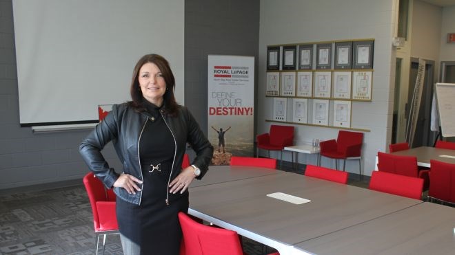 Sue Symons shows off the former gymnasium — now a training room and space for community gatherings — at the repurposed elementary school that’s now the new office for Royal LePage North Bay Real Estate Services. (Lindsay Kelly photo)