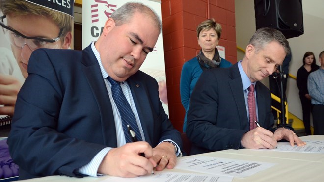 Laurentian University president Dominic Giroux and Cambrian College president Bill Best sign an MOU on March 8 to boost research efforts. Arron Pickard photo