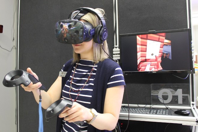 Wearing a virtual reality headset and holding handsets that allow her to manipulate onscreen equipment, communications officer Mélanie Watson demonstrates how the new VR programming works at Northern College.