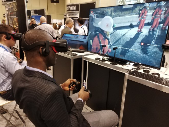 Visitors partake in virtual reality mine rescue demonstration simulations at NORCAT's booth at PDAC in early March. The innovation mill debuted the experimental program, along with a simulation of a Load, Haul, Dump driving simulation and an augmented reality training module for a fire extinguisher. 