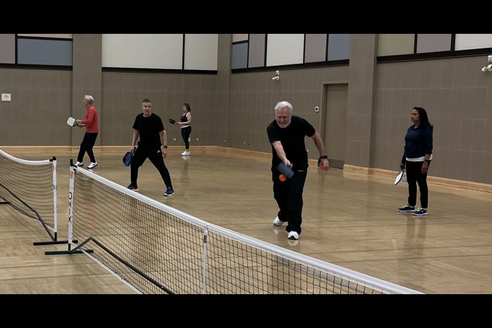 Mike Balsom (left) watches as NOTL Pickleball Club president John Hindle demonstrates a return