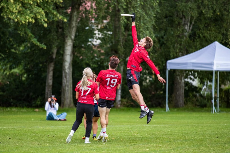 Ben Simmonds leaps for a catch as two of his Team Canada teammates look on