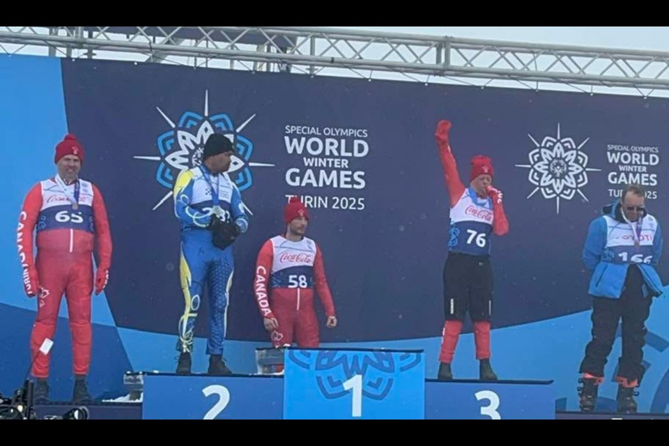 Carter Simpson (2nd from right) gives his bronze medal a kiss. Simpson finished third in the Intermediate Slalom race Saturday morning, his second bronze medal of the Special Olympics World Winter Games in Italy. 