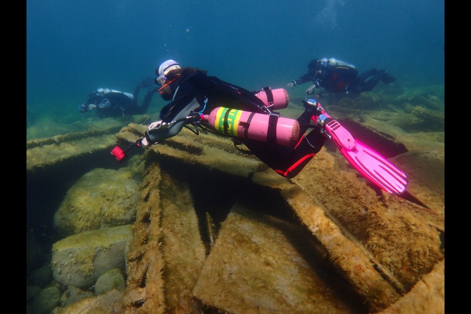 Diver swimming over the twisted metal remains of the Michigan