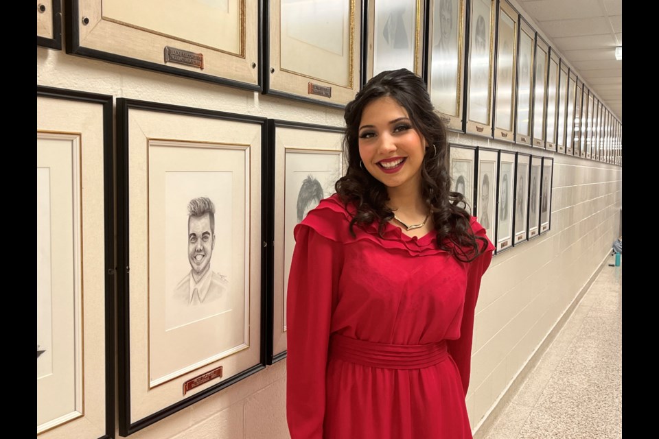 Grade 12 student Ayla Jamal in Laura Secord Secondary School's valedictorian hallway, where portraits of past class spokespeople are hung. 