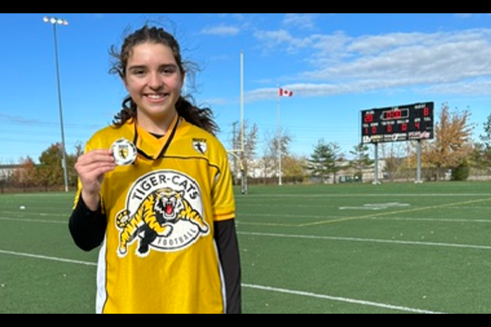 Gracie Cherney showing off the gold medal she won with her NRFF team last year.