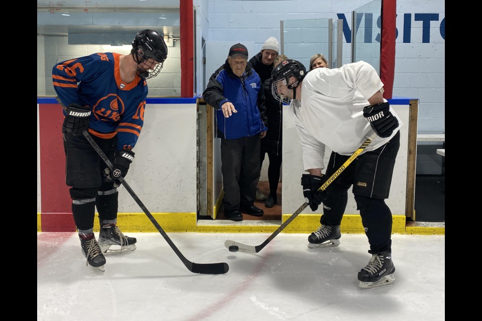Henry Berg drops the puck for the ceremonial opening faceoff at the James Berg Memorial Hockey Tournament, named for his late son. 