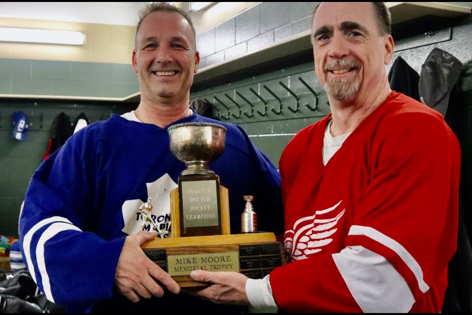 Rob Anderson receives the Mike Moore Memorial Cup — Moore was instrumental in establishing the league — from Tom Greenough.