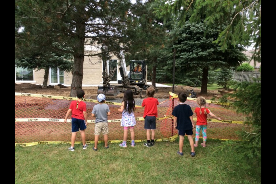 Niagara Nursery School students watch as the landscaping for the new expansion is underway.