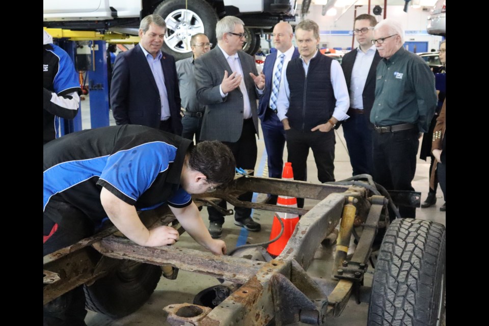 NOTL resident Jonathan Rolph removes a brake line from a chassis to ready it to be retrofitted with an electric battery for conversion into an electric vehicle. He’s at Niagara College attending an apprenticeship program. Watching him are Niagara Center MP Vance Badawey, Jeff Murrell (Associate Dean, School of Trades), Niagara College President Sean Kennedy, Federal Minister of Labour Seamus O’Regan, St.Catharines MP Chris Bittle, and Wayne Toth (Automotive Professor/Program Coordinator). O’Regan was at the college to check out the skilled trades and apprenticeship programs. 