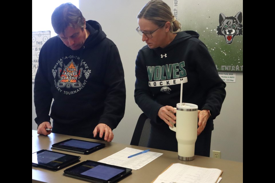 Tournament convenor James Cadeau and volunteer coordinator Carrie Plaskett check out one of the iPads used by the volunteer scorekeepers for each game. 