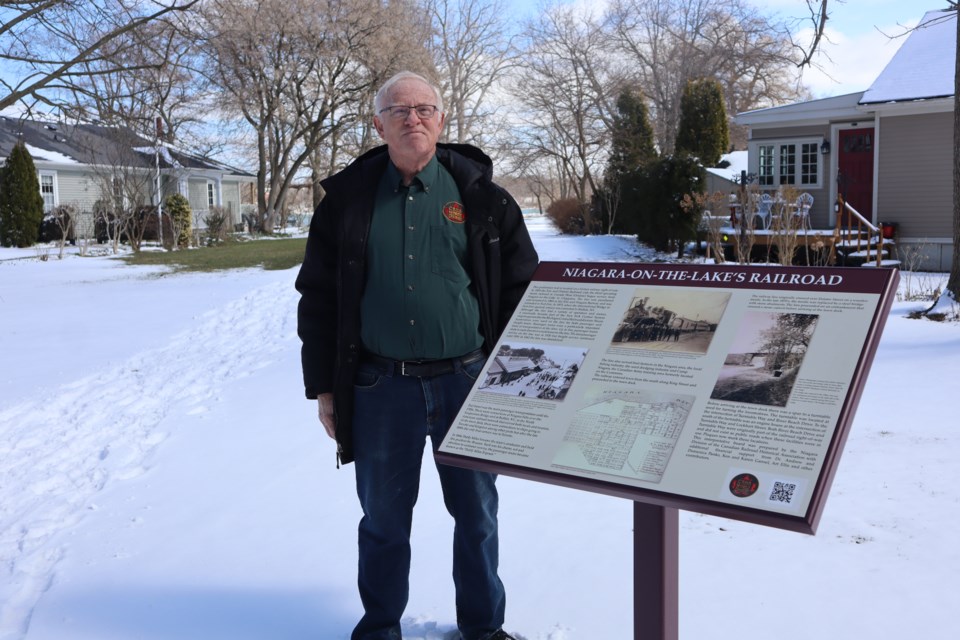 Paul Chapman, a past president of the CRHA, stands beside the new plaque installed on Delater Street. 