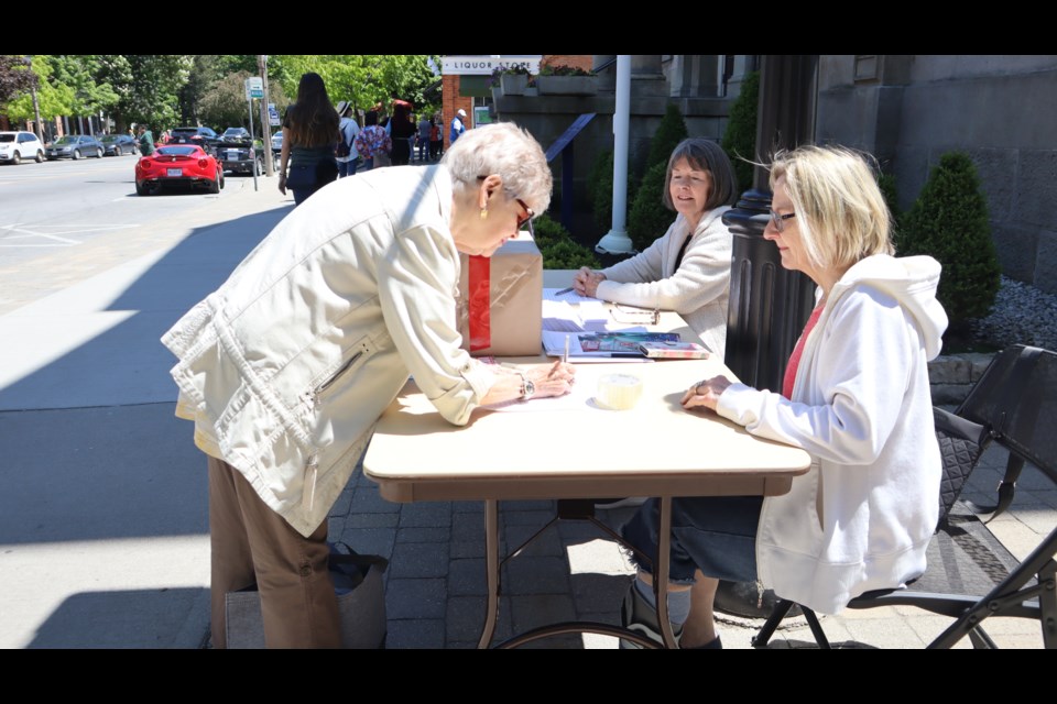 Gerda Ryckaert votes while Barb Cowie and Jennifer Roberts look on.