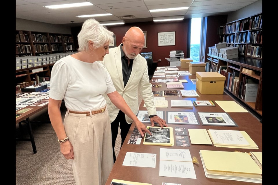 Debi Pratt and Donald Ziraldo look over a collection of photos of celebrity visits to the winery during a recent visit to the Brock University Archives.