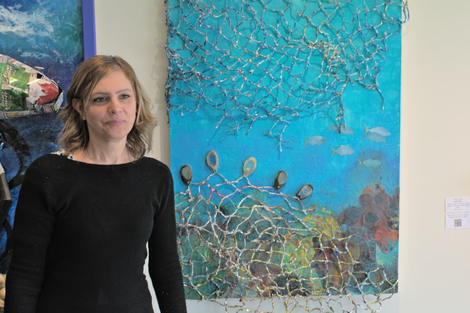North Vancouver-based artist Cath Hughes stands next to her piece 'Ghost Nets.'
