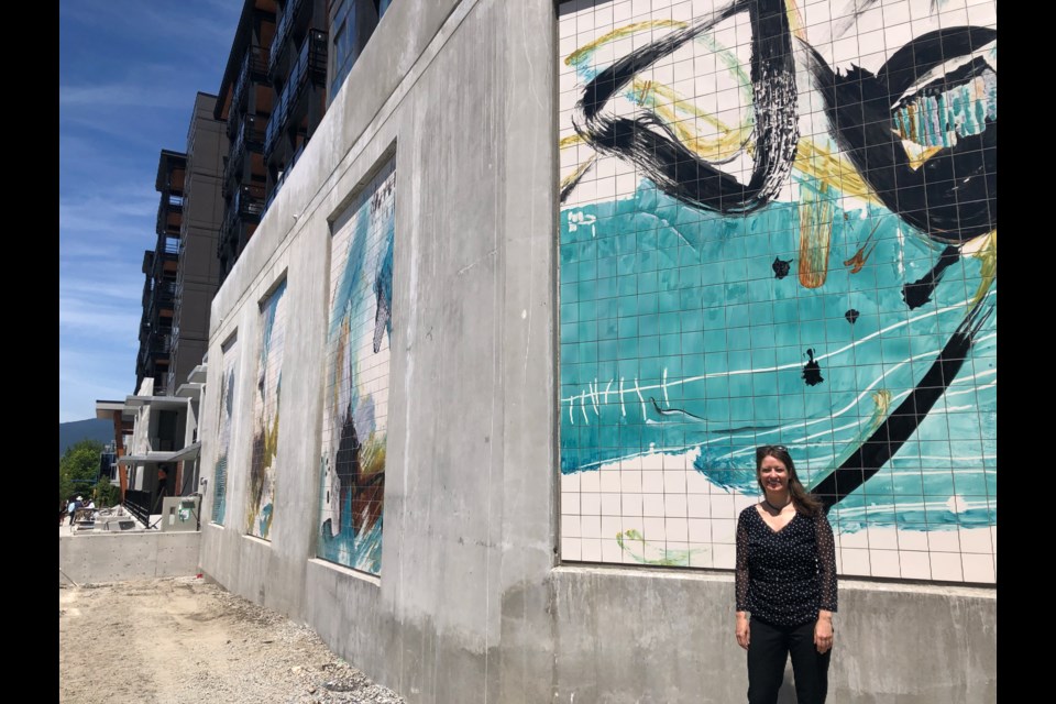 Canadian artist Deb Chaney stands in front of the completed West Coast Abstracts public art installation at 108 Eighth St. East, North Vancouver.