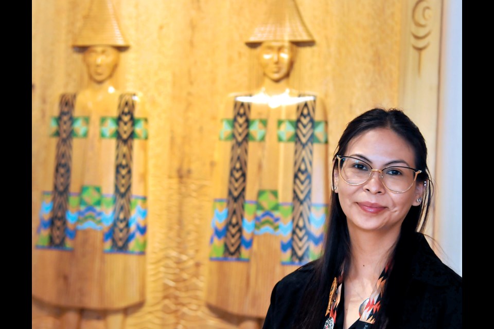 MONOVA Indigenous cultural programmer Jordan Dawson stands with The Twin Sisters panel carved by Squamish Nation's Halikium/Wade Baker in the entrance hall to the Museum of North Vancouver. MONOVA received a $400,000 grant to continue it's Coast Salish programming. | Paul McGrath, North Shore News