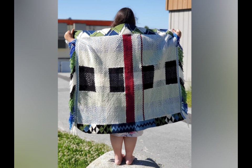 Caitlin Aleck of Tsleil-Waututh Nation displays a robe she has woven for artist Dan Friday’s Future Artifacts exhibition at the Museum of Northwest Art. 