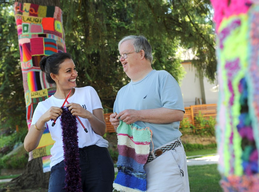 Simran Likhari, community arts projects lead at Cascadia Society, with Knitter William Skuse show off their 'yarn bombing' skills in front of the North Vancouver centre. The summer art project has helped brighten up the street. 