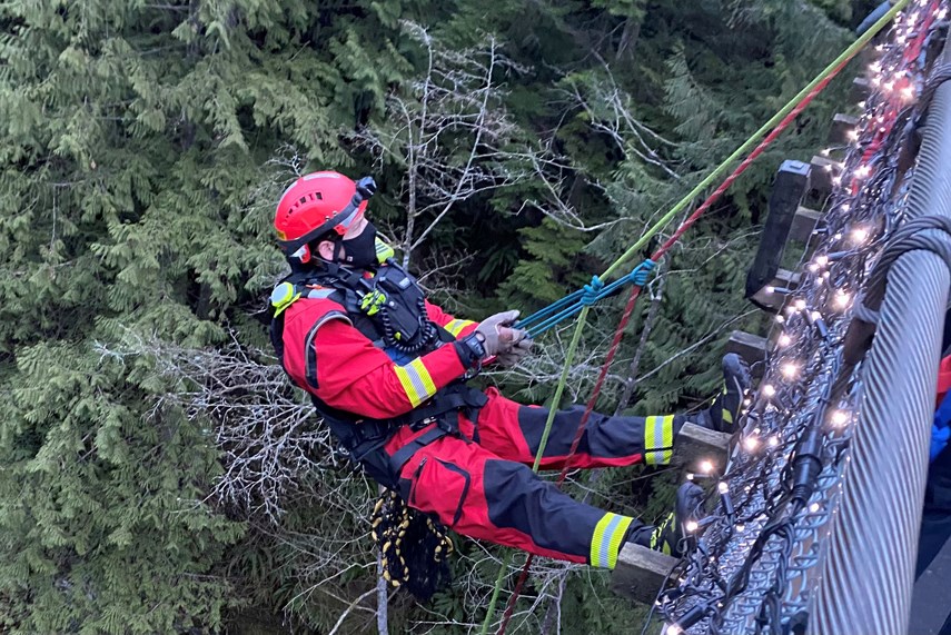 Members of District of North Vancouver Fire and Rescue Services make their way to a couple and their dog stranded near the Capilano Suspension Bridge, Saturday.