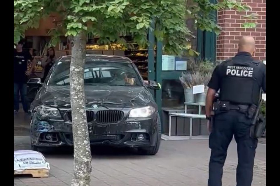 West Vancouver police oversee the removal of a BMW after the driver crashed through West Vancouver's Park Royal Whole Foods, June 9, 2023.
