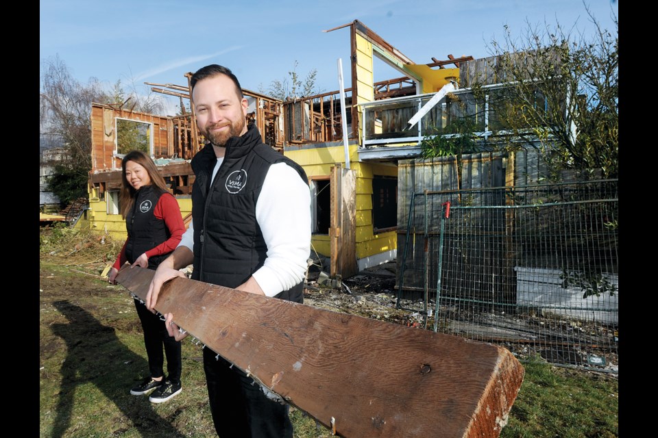 Erik Serpas Ventura and his wife Vannarady Lim grab some lumber that is being salvaged by their deconstruction company VEMA Deconstruction at the site of Jimmy Pattison's former home at Ambleside in West Vancouver. | Paul McGrath / North Shore News
