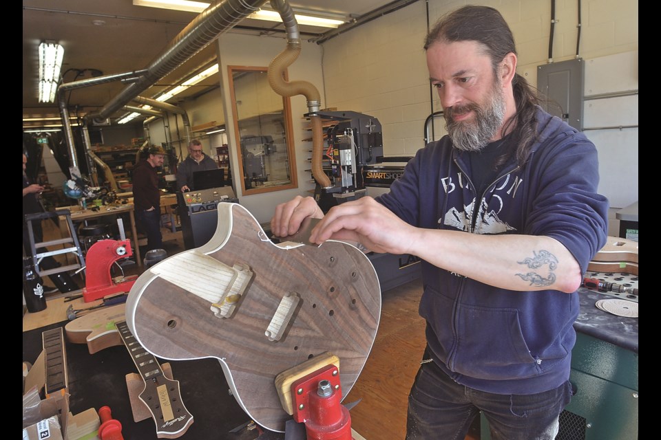 Luthier Wes Cook works on a guitar at Prestige Guitar's newly opened custom shop in North Vancouver. | Paul McGrath / North Shore News