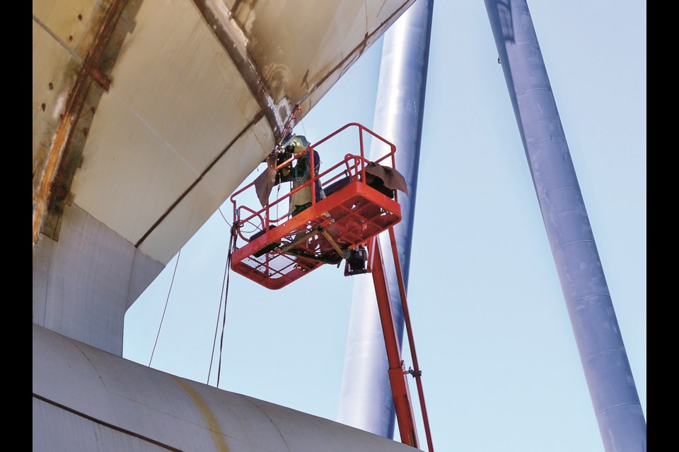 A welder works on the hull of the massive joint support ship taking shape at Seaspan's Vancouver Shipyards.