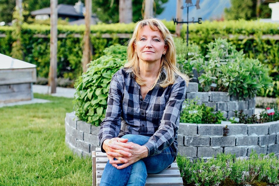 Urban  permaculture designer Laura Marie Neubert sits in her West Vancouver garden.