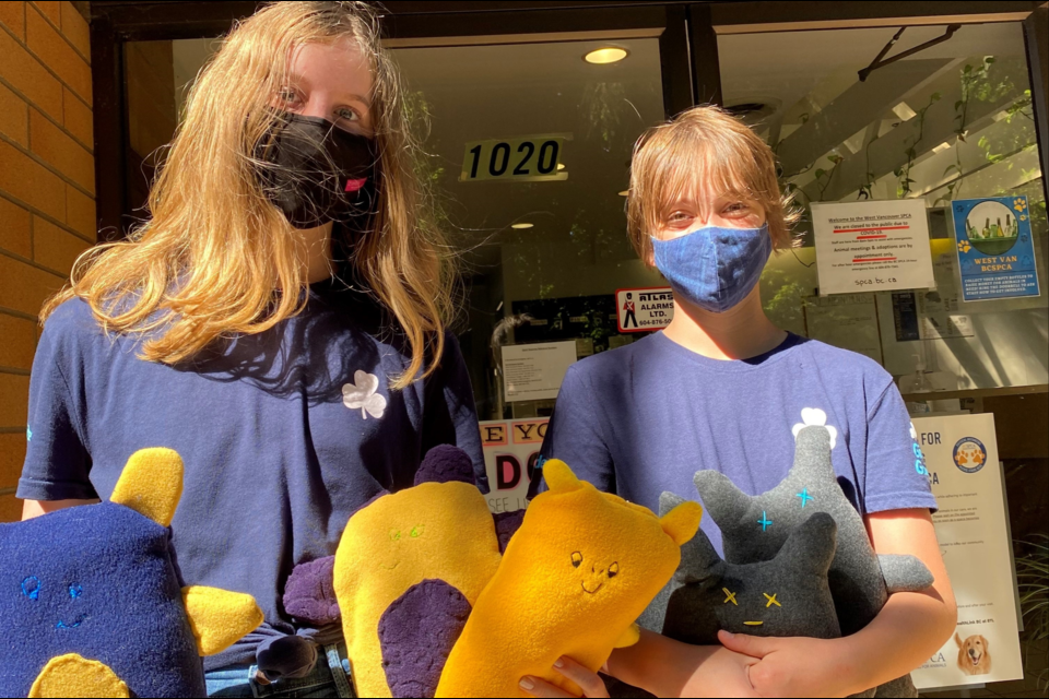 North Vancouver girl guides Georgia Chilton and Alice Link donate stuffed toys to BC SPCA West Vancouver branch for dogs to enjoy. 