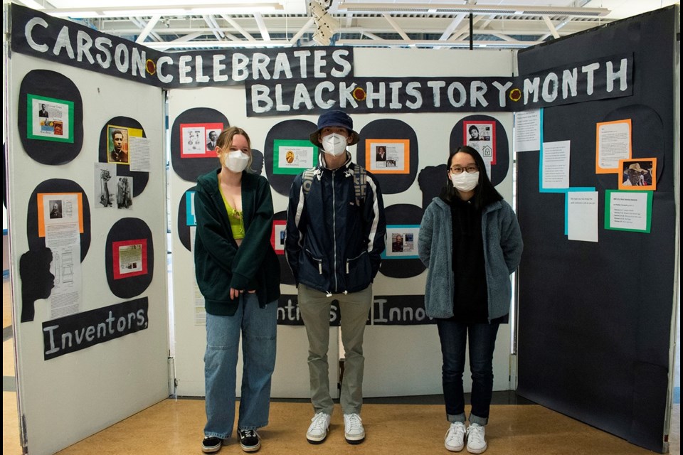 Sloane Barsky, Judelio Thiersch and Natsuki Hamazoe stand in front of the gallery walk that was set up at Carson Graham Secondary in celebration of Black History Month.