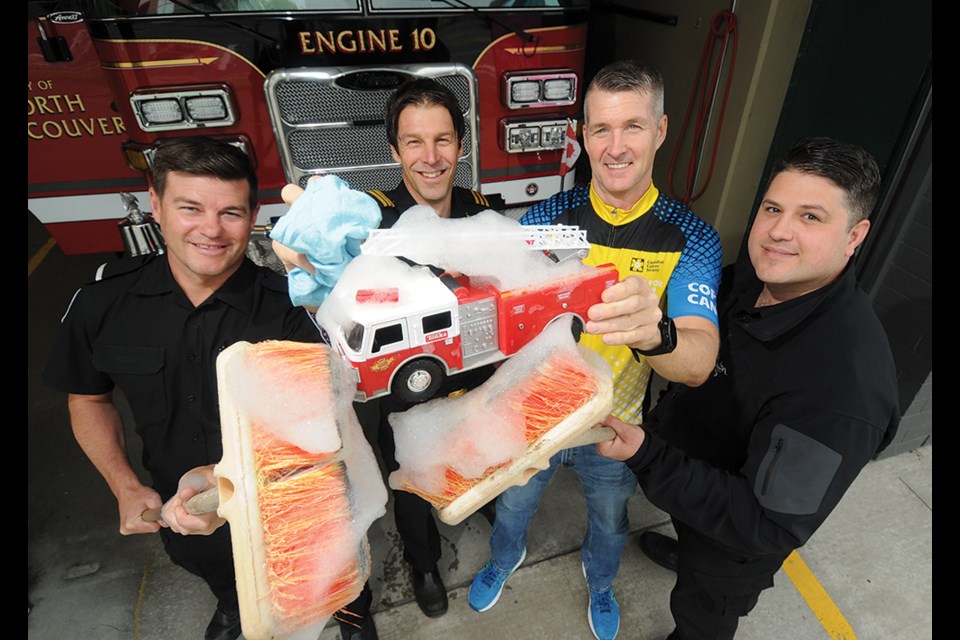 Joe Bovill, Mike Danks, Darren Beckett and Joel Urbani scrub a toy fire truck. They'll do the same thing to your full-sized vehicle by donation at the North Vancouver City Fire Department  on June 11, 2022.
 