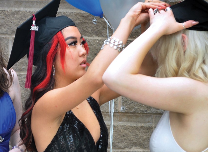 Rockridge Secondary Grade 12 students Lili Goodwin and Rose Foy get prepped for graduation ceremonies May 31, 2021, at West Vancouver's Kay Meek Arts Centre.