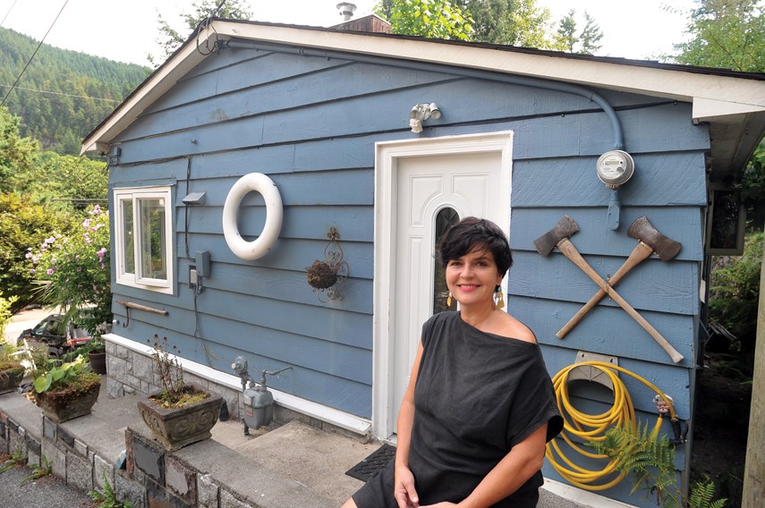 Heidi Woodley stands by her rented heritage cottage on Nelson Avenue in West Vancouver's Horseshoe Bay, one of eight such cottages across three lots. Woodley and others have started the Horseshoe Bay Cottagers' Collective to attempt to purchase the properties through a co-ownership structure. 