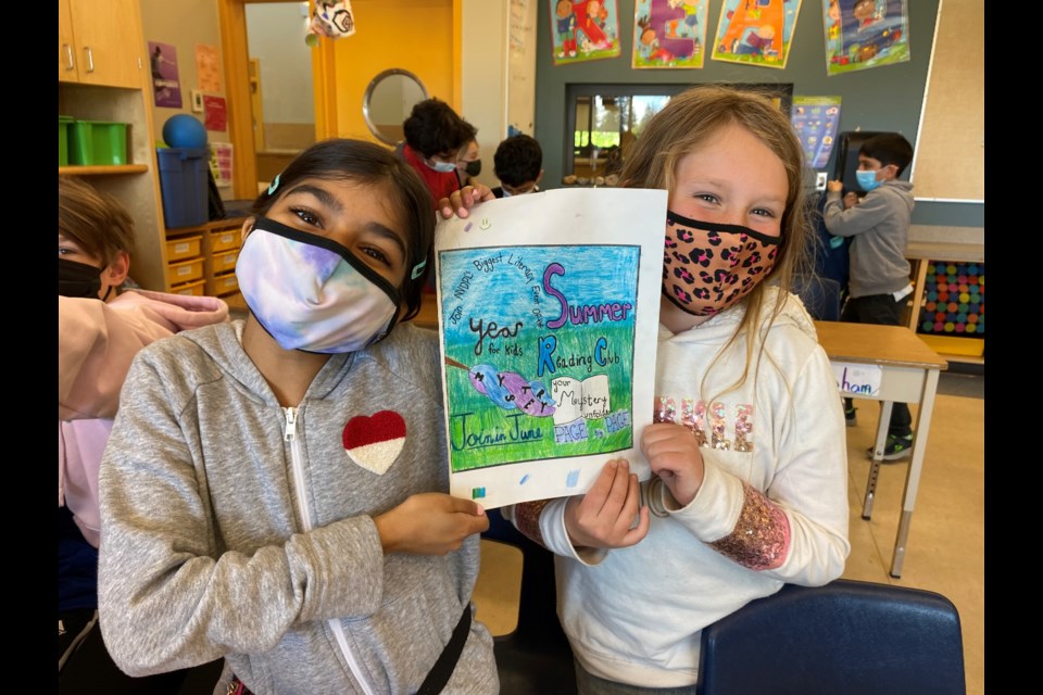 Highlands Elementary Grade 5 students  Jenna Pardhan and Josie Dalrymple with the one of the pieces they put together for the Kids Design Your Ads project.