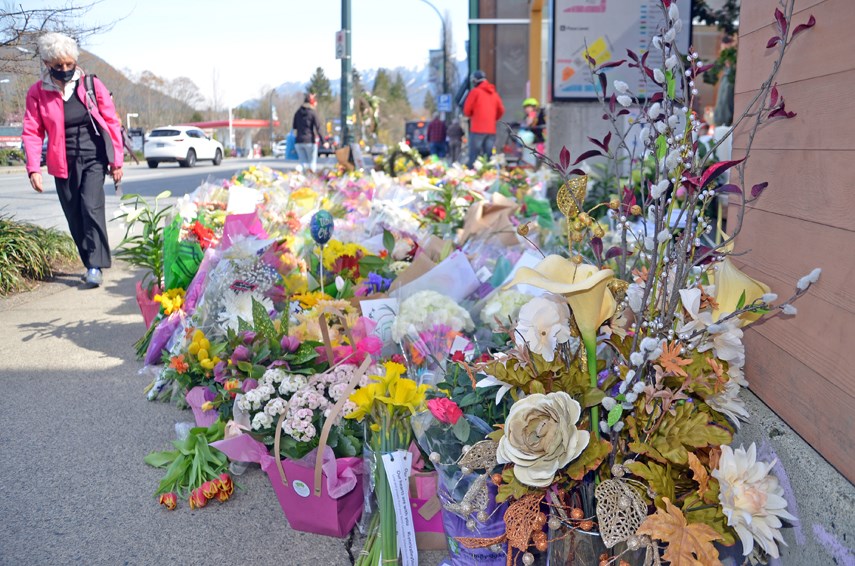 Hundreds of flowers line the sidewalk outside the Lynn Valley Village library complex. On Wednesday, March 31, the library reopened four days after a multi-victim stabbing that left one woman dead and sent six people to hospital.